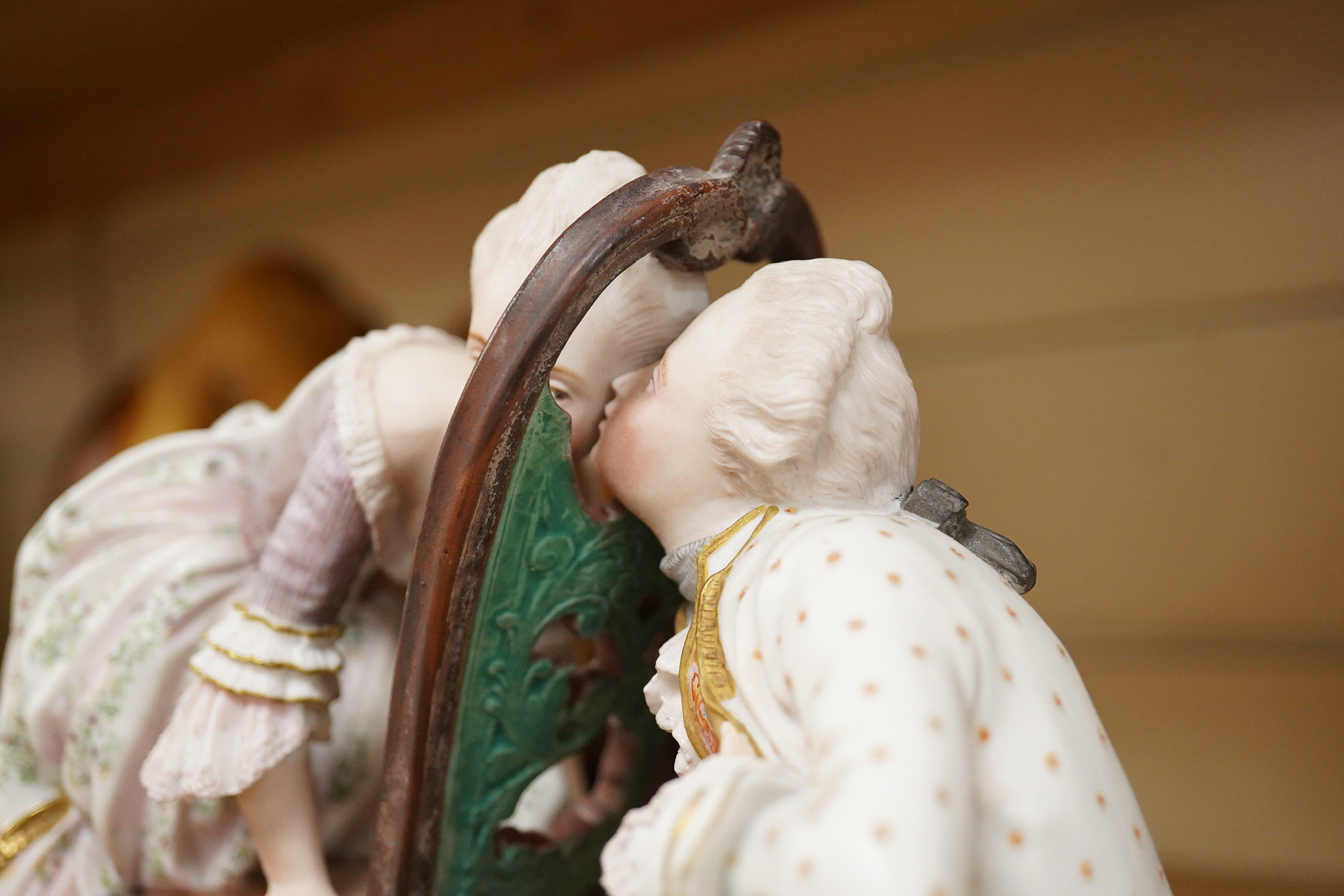 A 19th century biscuit porcelain study of a courting couple under glass dome, raised on gilt base, 28cm high